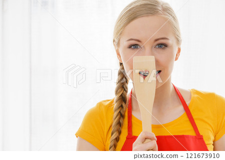 Woman holding wooden spatula with heart 121673910