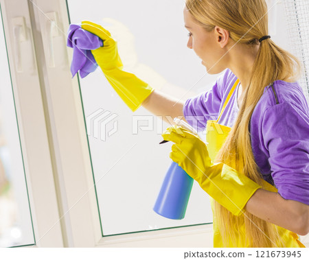 Girl cleaning window at home 121673945