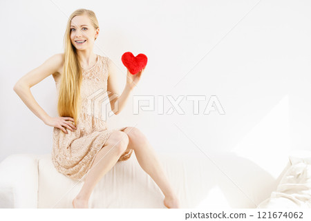 Happy young woman holding red heart 121674062