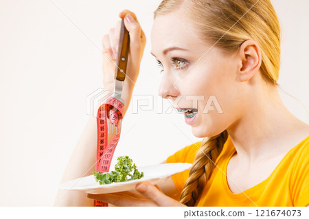 Woman on diet holding plate with lettuce Woman on diet holding plate with lettuce 121674073