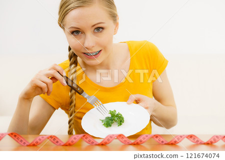 Woman on diet holding plate with lettuce Woman on diet holding plate with lettuce 121674074