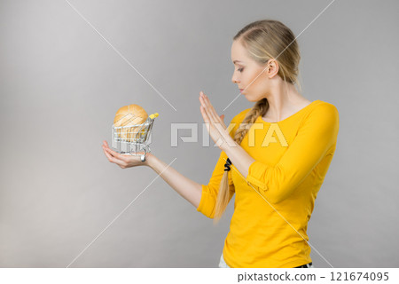 Woman holding shopping cart with bread 121674095