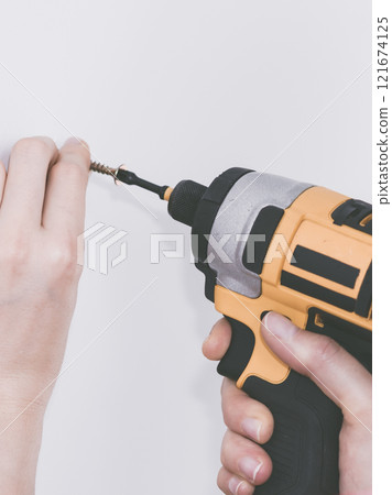 Person drilling in wall Person drilling in wall 121674125