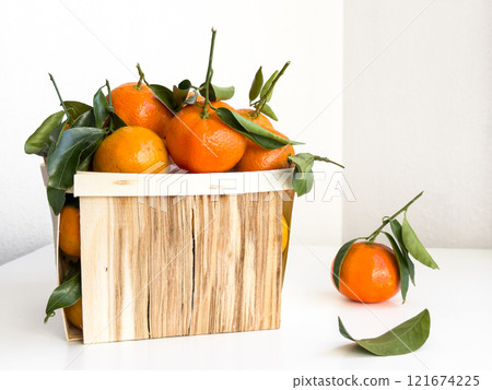 Fresh mandarins in wooden box on white background Fresh mandarins in wooden box on white background 121674225