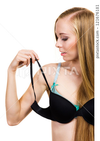 Woman trying on black bra 121676181