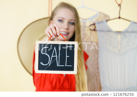 Woman in shop with sale sign Woman in shop with sale sign 121676250