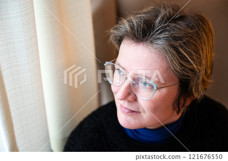 Window portrait of a 38 yo white woman at home in Brussels Old Town, Belgium Window portrait of a 38 yo white woman at home in Brussels Old Town, Belgium 121676550