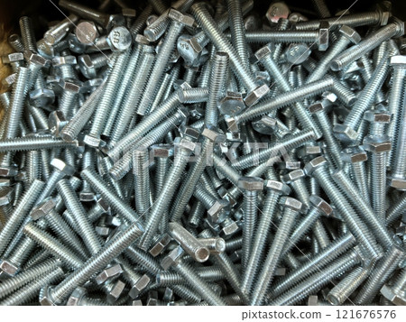 Metallic bolts scattered across a workshop surface at mid-day Metallic bolts scattered across a workshop surface at mid-day 121676576