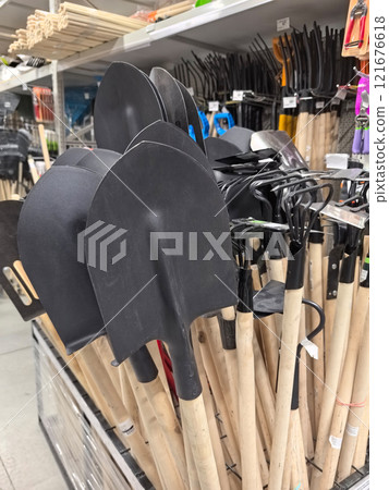 Garden tools lined up for selection in a bright retail store space Garden tools lined up for selection in a bright retail store space 121676618