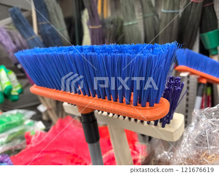 Bright blue cleaning brush displayed among various tools in a store Bright blue cleaning brush displayed among various tools in a store 121676619