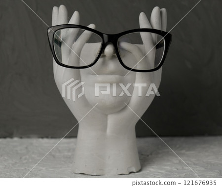 Monochrome style, white headless figure in a pensive pose wearing black-rimmed glasses 121676935
