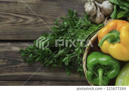 bell peppers and fresh basil, dill, parsley, cilantro, tomatoes, garlic, asparagus on a wooden table. top view. Flat lay 121677269