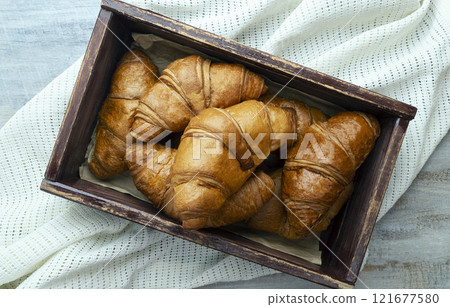 Freshly baked croissants on wooden background Warm Fresh Buttery Croissants and Rolls. food pastry for menu, cafe. 121677580