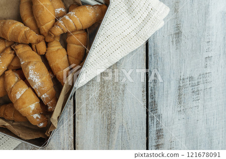Croissant and cup of hot drink on white table in kitchen, space for text. Freshly baked croissants. Bakery products Croissant and cup of hot drink on white table in kitchen, space for text. Freshly baked croissants. Bakery products 121678091