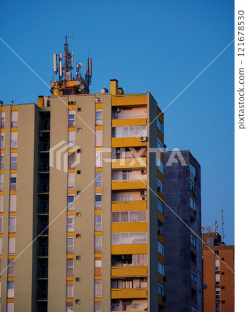 Cellular antennas and transmitters on roof of residential building. Radio transmitting equipment and communication lines on roof. 5G antennas. Evening sunset sky. Pula, Croatia - January 3, 2025 Cellular antennas and transmitters on roof of residential building. Radio transmitting equipment and communication lines on roof. 5G antennas. Evening sunset sky. Pula, Croatia - January 3, 2025 121678530