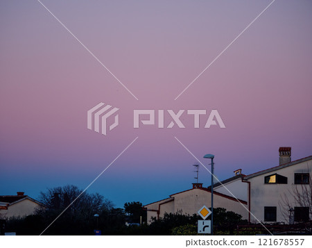 Beautiful color transitions in the sky at dusk after sunset. Natural beauty in nature. Landscape with roofs of city houses. Natural gradient background. Pula, Croatia - January 3, 2025 Beautiful color transitions in the sky at dusk after sunset. Natural beauty in nature. Landscape with roofs of city houses. Natural gradient background. Pula, Croatia - January 3, 2025 121678557
