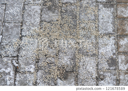 Salt covers sidewalk, street in winter to prevent icy hazards. Urban ice treatment, fall prevention 121678589