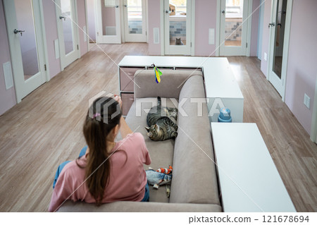 Female employee and cat game with string toy, cat stay as comfortable as possible. Cat toys, comfort Female employee and cat game with string toy, cat stay as comfortable as possible. Cat toys, comfort 121678694