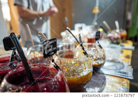 Bowls of sweet jams, fruit preserves displayed on stall at local fair, small business food products 121678797