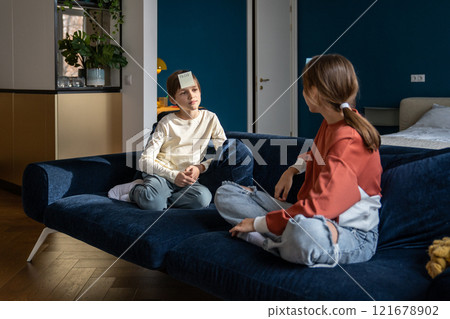 Two kids brother and sister playing guessing game Who am I at home 121678902