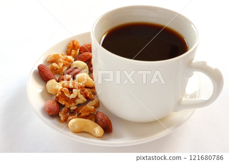 Coffee and mixed nuts on white background 121680786