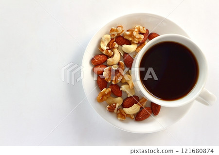 Coffee and mixed nuts on white background Coffee and mixed nuts on white background 121680874