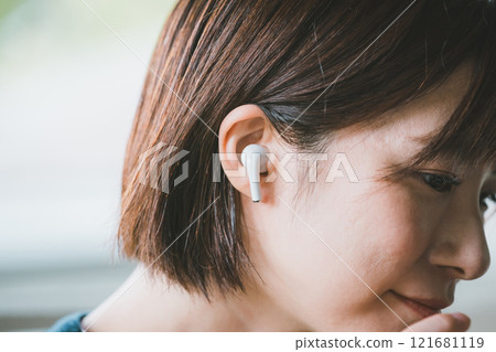 Woman wearing wireless earphones Woman wearing wireless earphones 121681119
