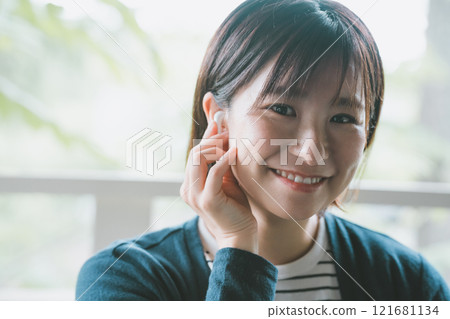 Woman using wireless earphones Woman using wireless earphones 121681134