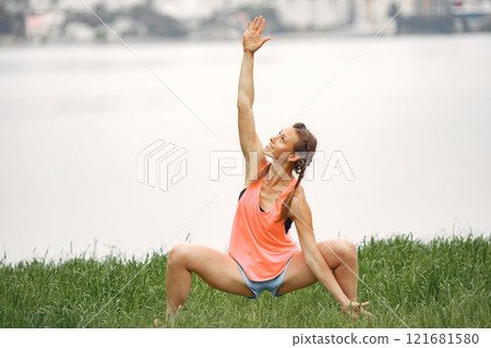 Sports girl by the water. Woman in a summer park. Lady in a pink sportswear. Sports girl by the water. Woman in a summer park. Lady in a pink sportswear. 121681580