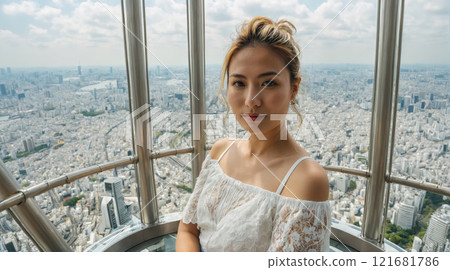 Woman enjoying panoramic city view from tall observation deck in Tokyo on a sunny day Woman enjoying panoramic city view from tall observation deck in Tokyo on a sunny day 121681786