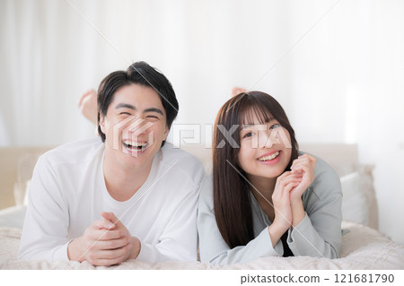 一對微笑的夫婦看著鏡頭在臥室放鬆 121681790