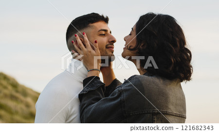 Engaged couple kissing each other outdoors Engaged couple kissing each other outdoors 121682343