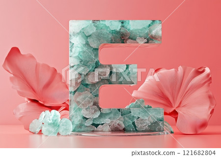 The letter E is made of colorful stones and is sitting on a table 121682804