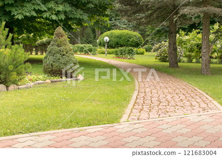a beautiful and well-kept park with paths of fir trees and flowers a beautiful and well-kept park with paths of fir trees and flowers 121683004