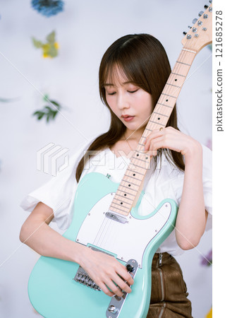 拿著電吉他的長髮年輕女子 拿著電吉他的長髮年輕女子 121685278