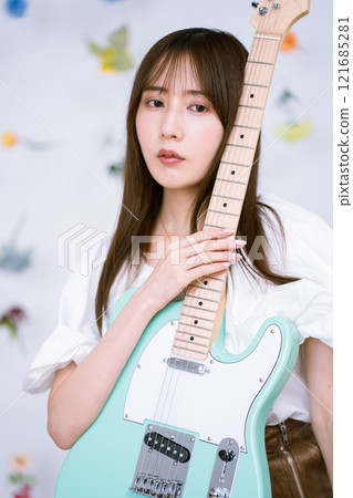 Long-haired young woman with an electric guitar 121685281