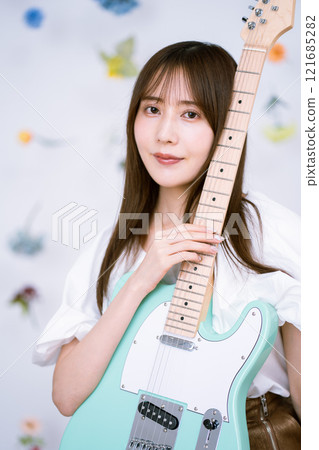 Long-haired young woman with an electric guitar 121685282