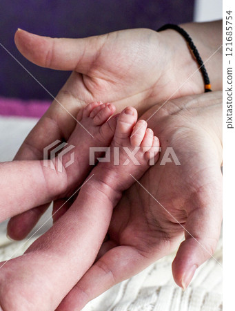 Handles and legs of the newborn baby 121685754