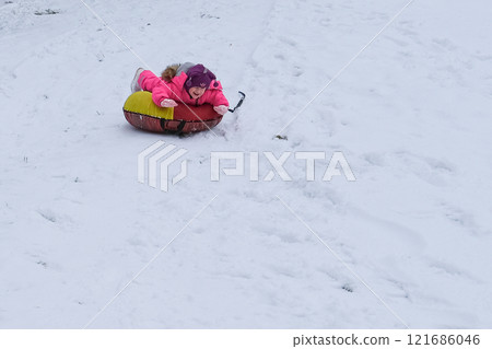 A child rides a tube down the mountain A child rides a tube down the mountain 121686046
