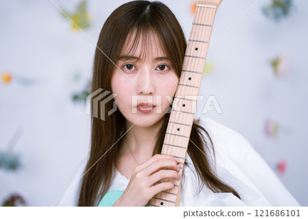 拿著電吉他的長髮年輕女子 121686101