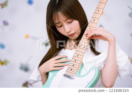 Long-haired young woman with an electric guitar 121686103