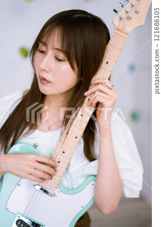 Long-haired young woman with an electric guitar 121686105