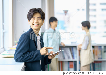 在辦公室工作的穿著便衣的年輕男商人 121686317