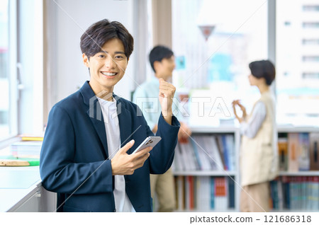 在辦公室工作的穿著便衣的年輕男商人 121686318