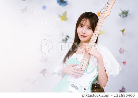 Long-haired young woman with an electric guitar 121686400