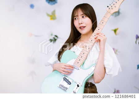 Long-haired young woman with an electric guitar 121686401