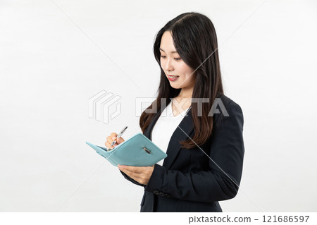 Businesswoman thinking while looking at her notebook 05 121686597