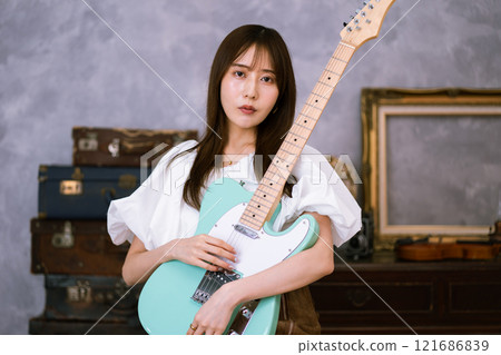 拿著電吉他的長髮年輕女子 121686839