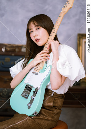 拿著電吉他的長髮年輕女子 拿著電吉他的長髮年輕女子 121686846