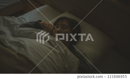 一個睡在床上的年輕女人 121686955